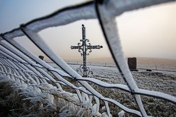 Frost and fog on an iron cross at a small cemetery south of Lowry.
