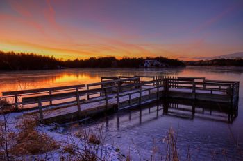 Winter sunset over the ice and fishing pier at Lake Alvin Recreation Area near Harrisburg.